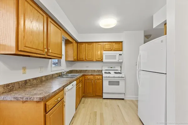 a kitchen with a sink a refrigerator and cabinets