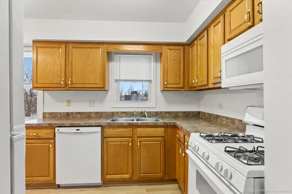 a kitchen with granite countertop wooden cabinets stainless steel appliances and a window