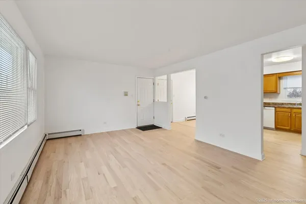 a view of empty room with wooden floor and window