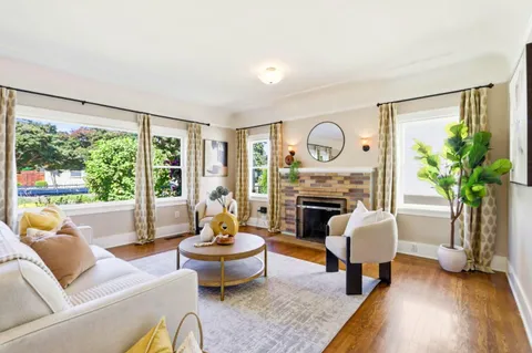 a living room with furniture fireplace and a large window