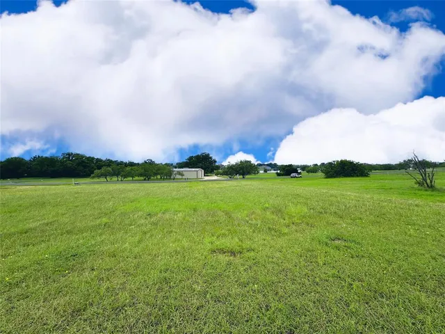 a view of a big yard with a house in the background