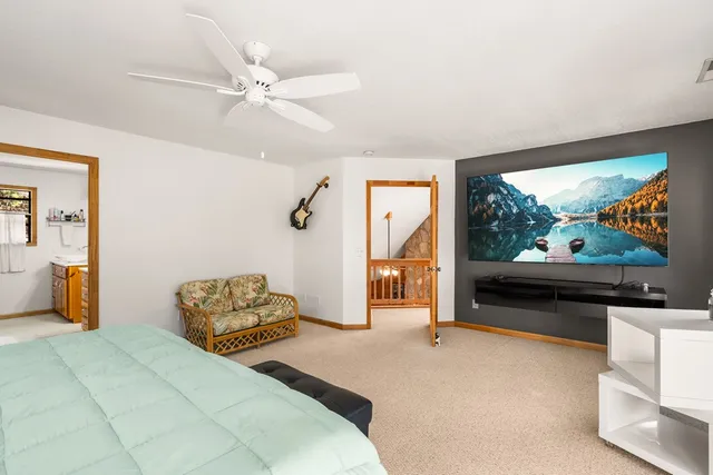 a bedroom with a bed and a flat tv screen on dresser