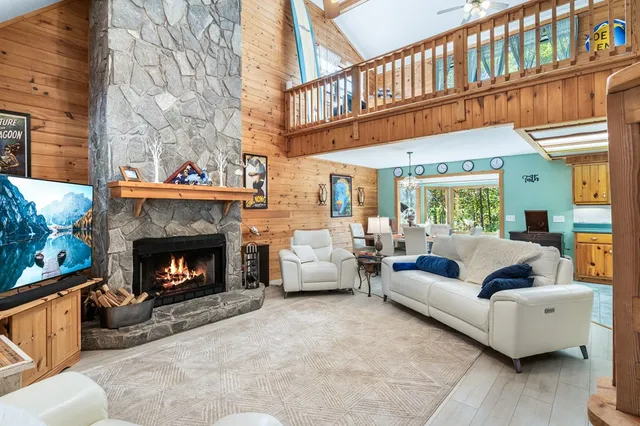 a living room with furniture a fireplace and a large window