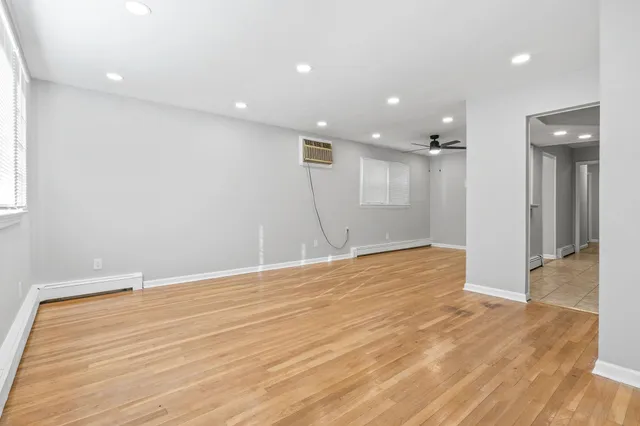 a view of an empty room with wooden floor