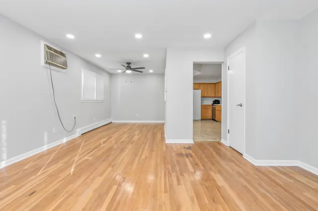 a view of empty room with wooden floor