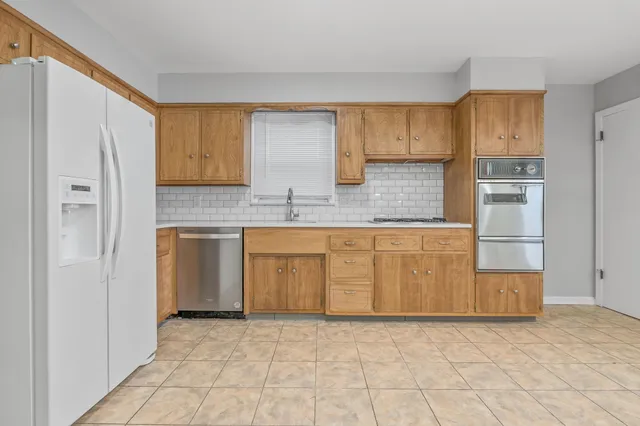 a kitchen with white cabinets and a refrigerator