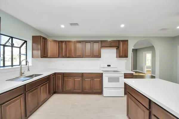 a kitchen with a sink stove and cabinets