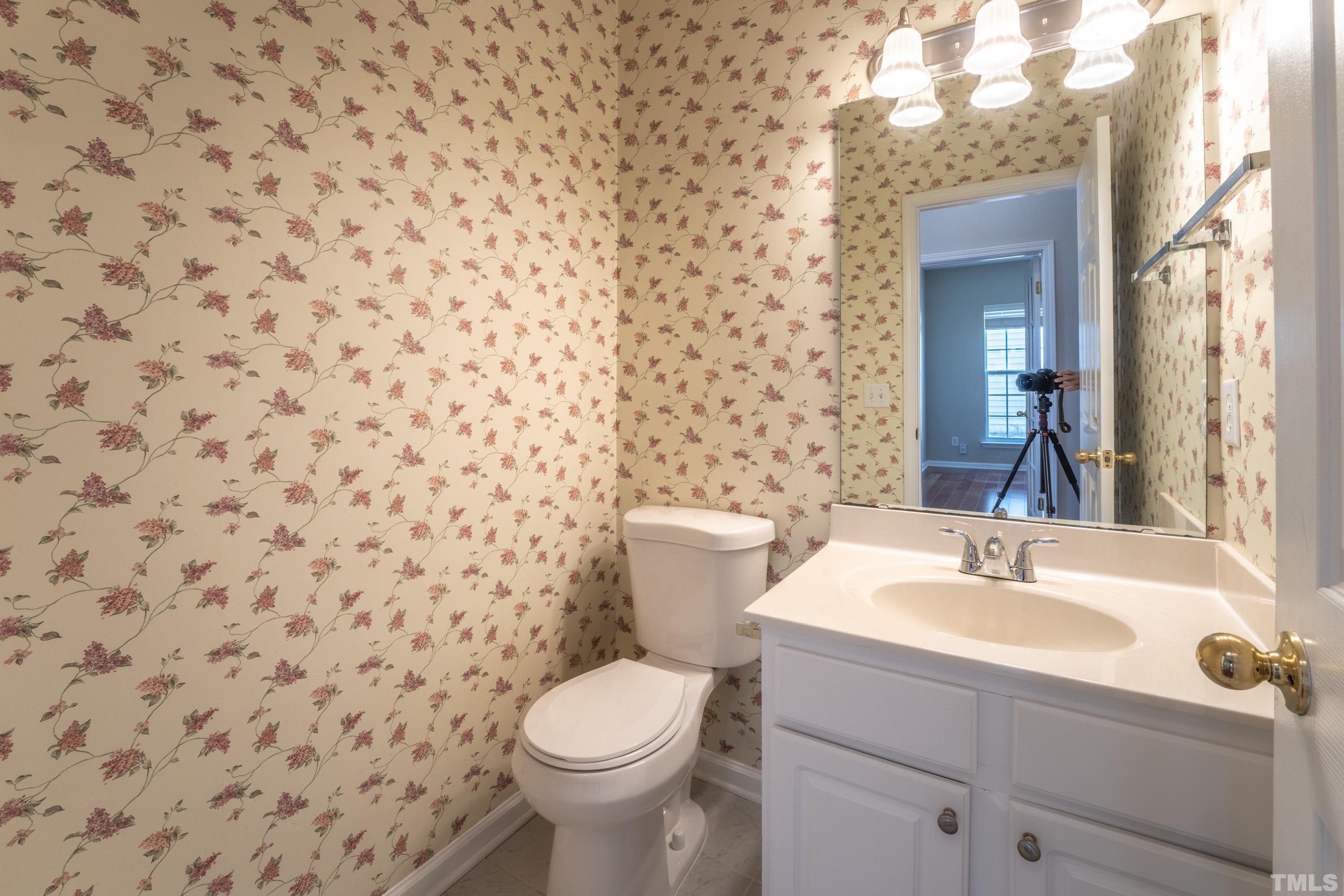 5455 Wind Mountain Lane Raleigh, NC 27613 - Photo 13 of 28 a bathroom with a sink a toilet and mirror