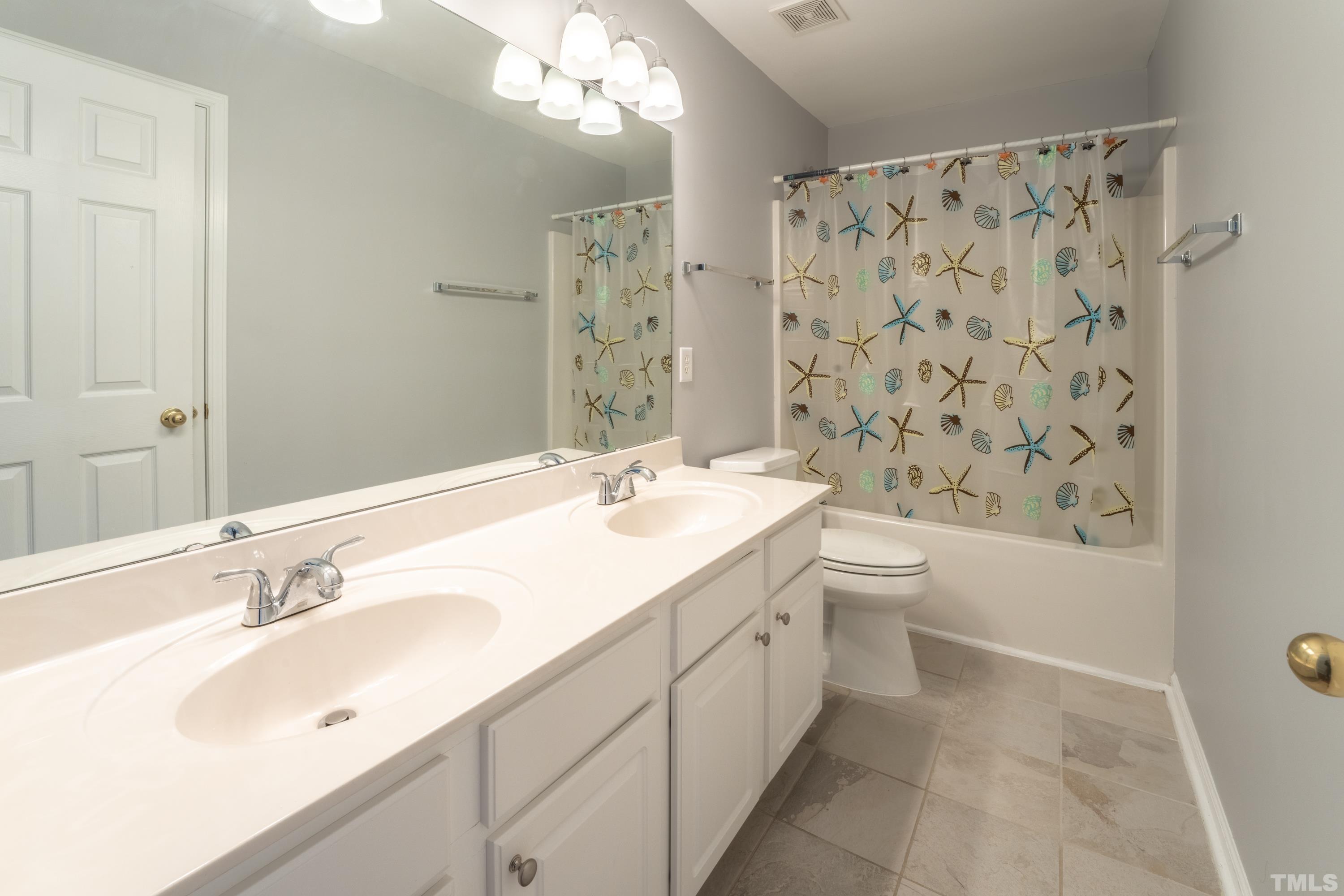 5455 Wind Mountain Lane Raleigh, NC 27613 - Photo 16 of 28 a bathroom with a double vanity sink toilet mirror and shower