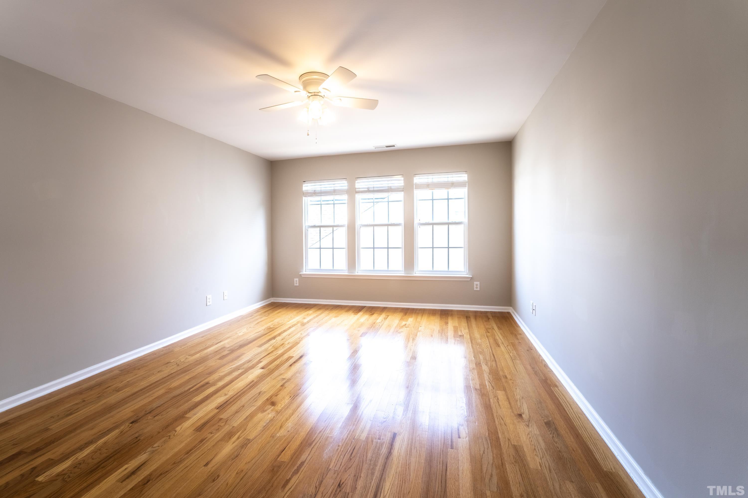 5455 Wind Mountain Lane Raleigh, NC 27613 - Photo 18 of 28 an empty room with wooden floor and windows