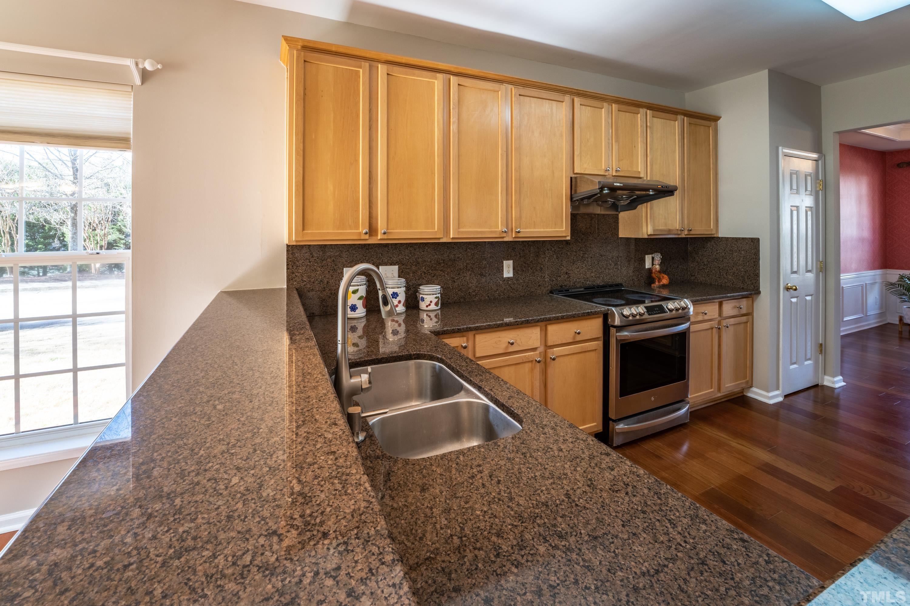 5455 Wind Mountain Lane Raleigh, NC 27613 - Photo 6 of 28 a kitchen with a sink a stove and a microwave