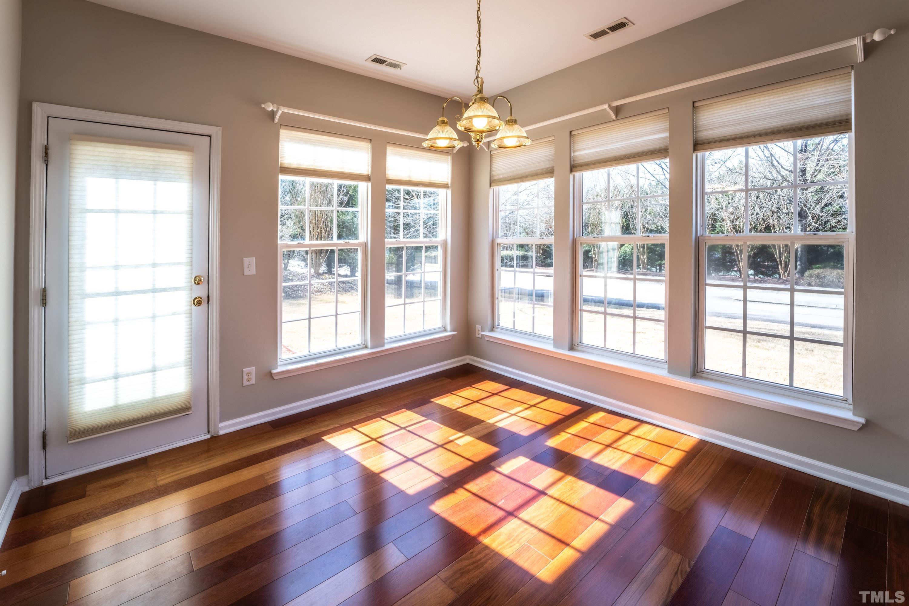 5455 Wind Mountain Lane Raleigh, NC 27613 - Photo 8 of 28 a view of an empty room with wooden floor and a window