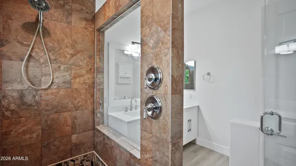 a bathroom with a double vanity sink mirror and shower