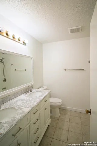 a bathroom with a sink shower and a mirror