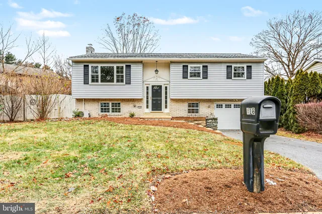 a front view of a house with a yard covered with trees
