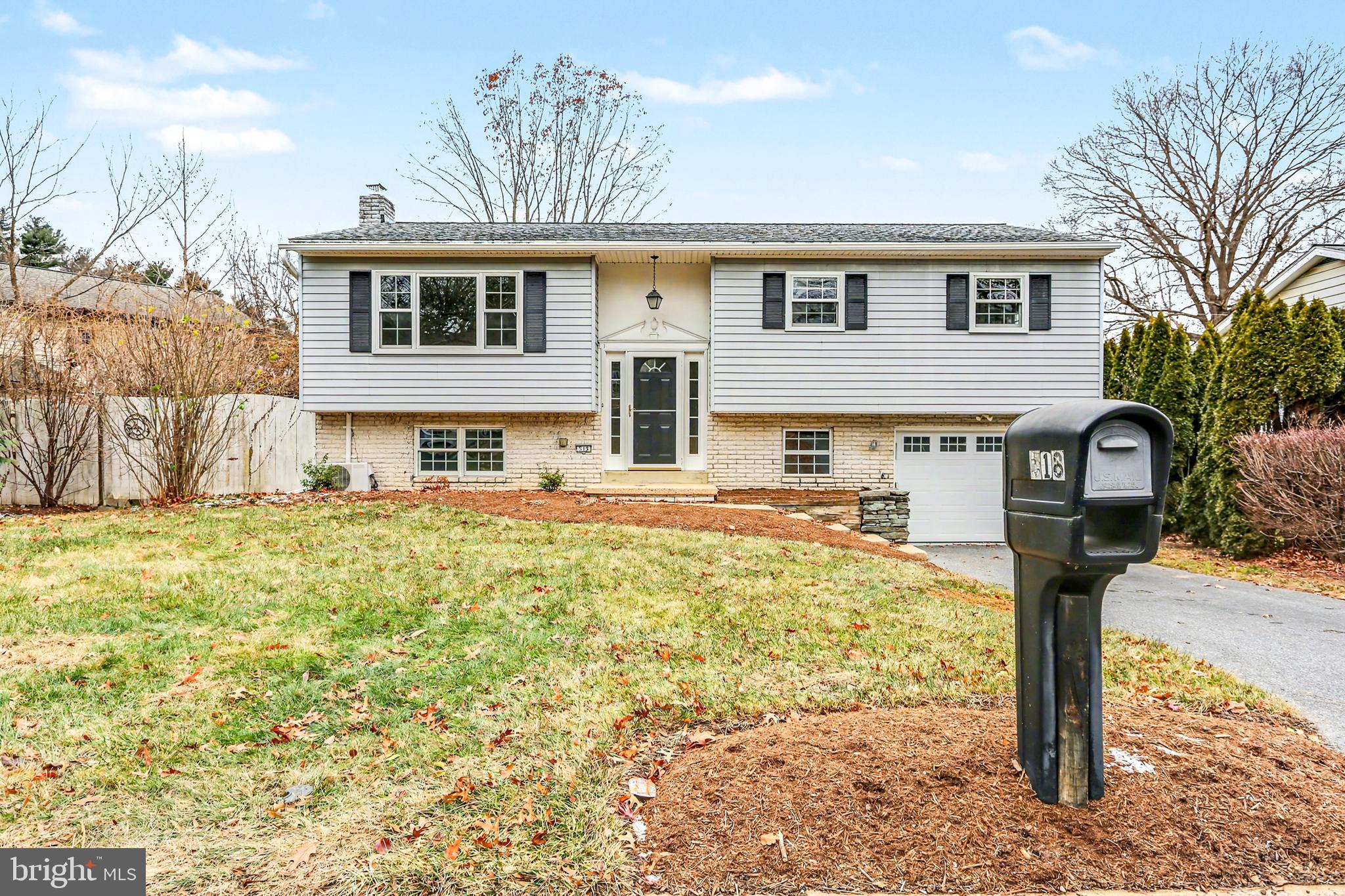a front view of a house with a yard covered with trees