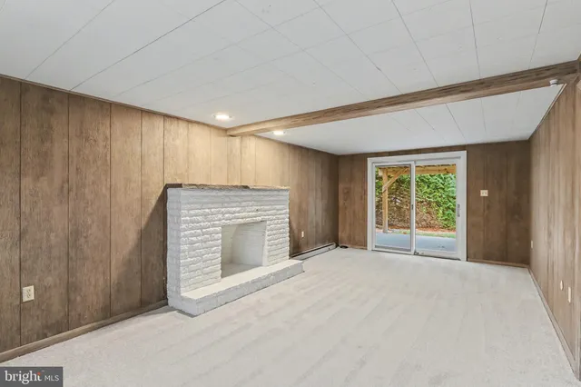 a view of an empty room with a fireplace and a window