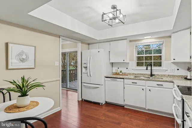 a kitchen with stainless steel appliances a sink a window and wooden floor