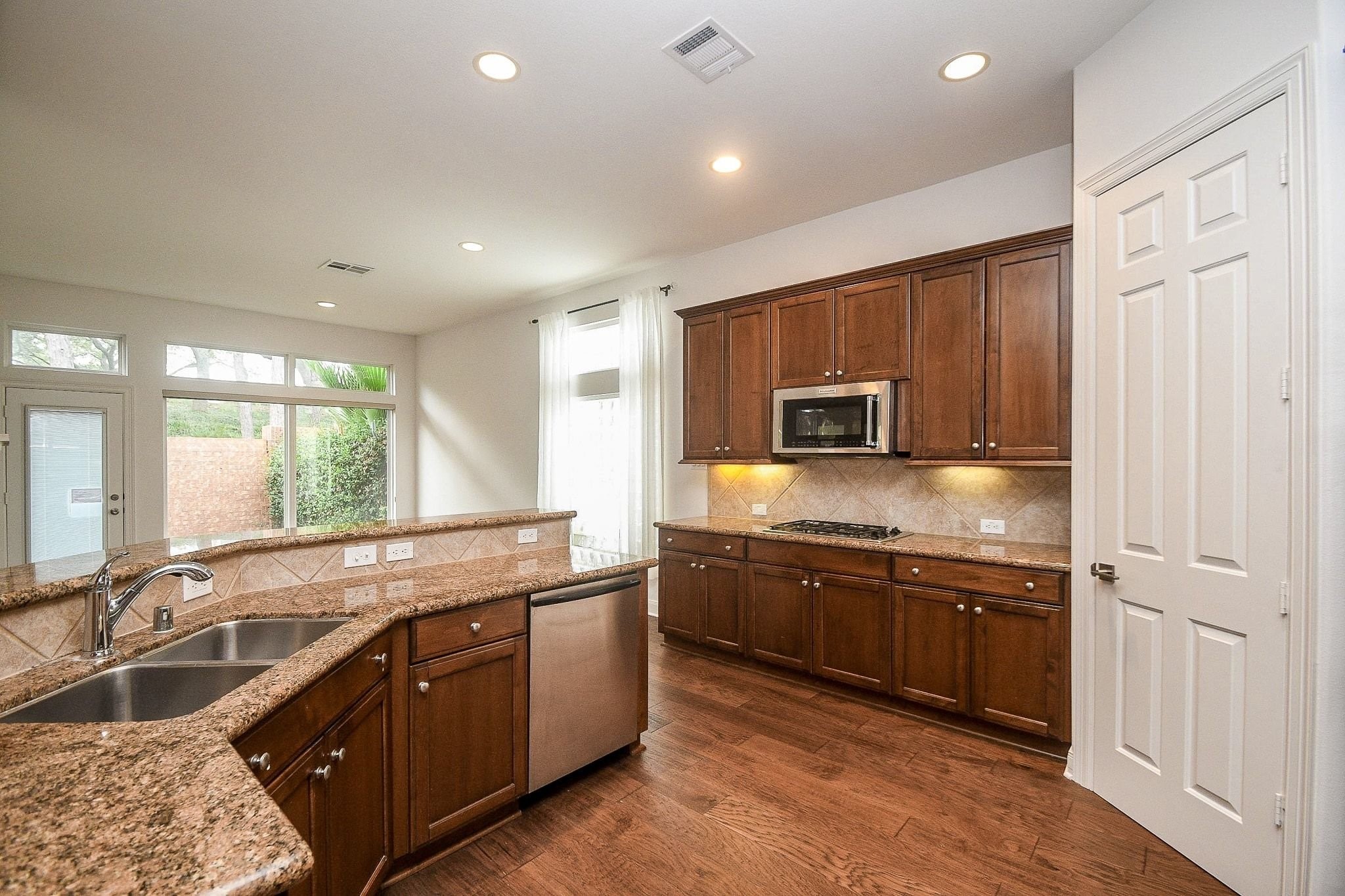 2826 Tudor Manor Houston, TX 77082 - Photo 13 of 37 The kitchen features stainless steel appliances, a gas cooktop, elegant undermount lighting, and a spacious raised countertop.