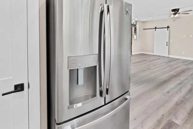 an empty room with wooden floor and a hallway