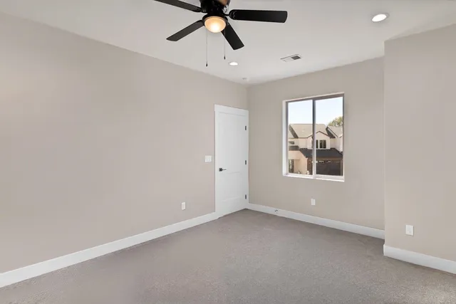 an empty room with windows and fan