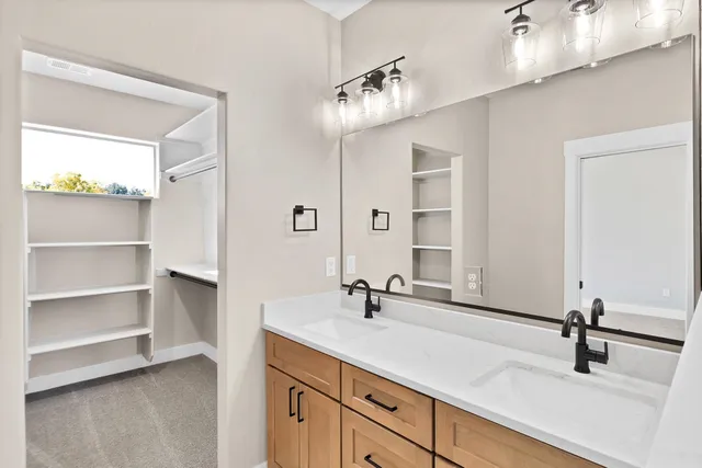 a bathroom with a double vanity sink a mirror and a shower