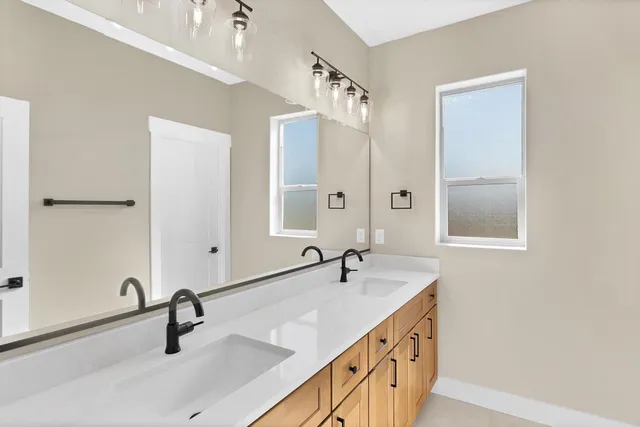 a bathroom with double sink and a mirror