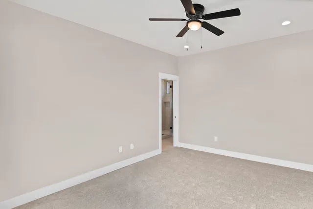 an empty room with a ceiling fan and window