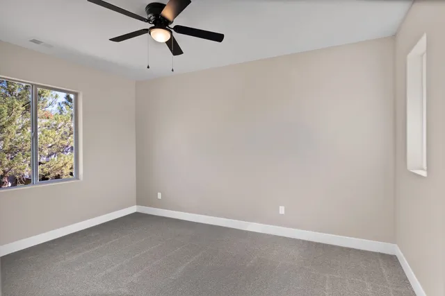 an empty room with a window and a fan