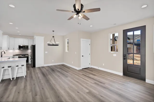 a view of an empty room with window and wooden floor