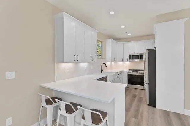a kitchen with stainless steel appliances a refrigerator and a stove top oven