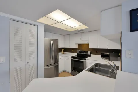a kitchen that has a refrigerator and a stove top oven
