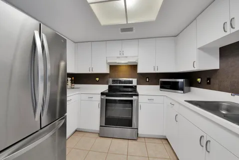 a kitchen with cabinets stainless steel appliances and a counter space