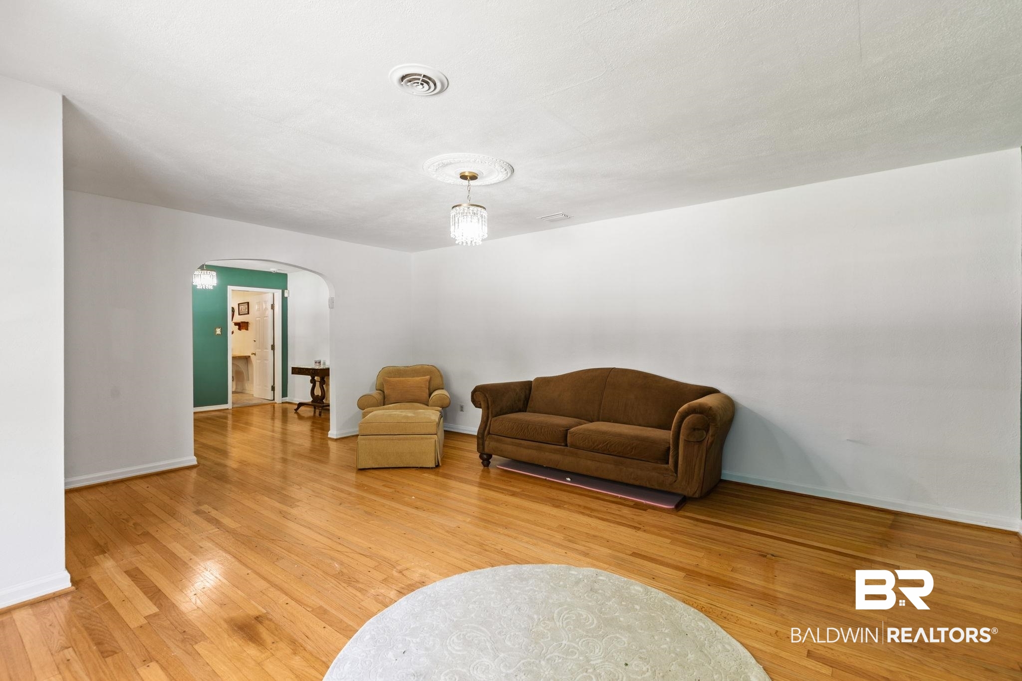 927 Cleveland Road Saraland, AL 36571 - Photo 5 of 80 Hardwood flooring throughout a spacious room with a decorative ceiling medallion and a central light fixture