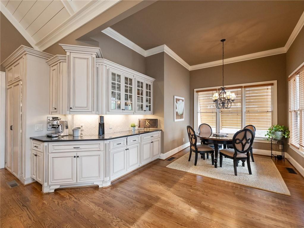 6147 Golf View Court Jefferson, GA 30549 - Photo 17 of 73 a large white kitchen with granite countertop a sink dishwasher a dining table and chairs with wooden floor