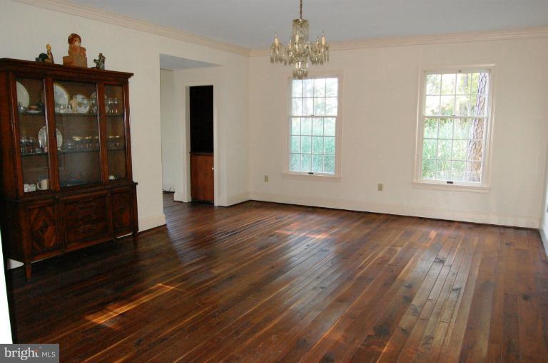 6937 Pea Neck Road St. Michaels, MD 21663 - Photo 12 of 22 an empty room with wooden floor chandelier and windows