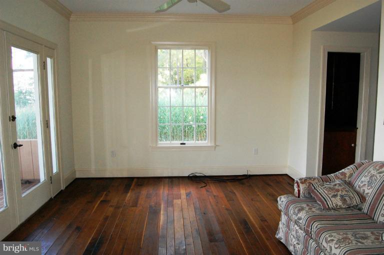 6937 Pea Neck Road St. Michaels, MD 21663 - Photo 19 of 22 an empty room with wooden floor and windows
