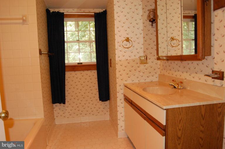 6937 Pea Neck Road St. Michaels, MD 21663 - Photo 4 of 22 a bathroom with a sink and a mirror