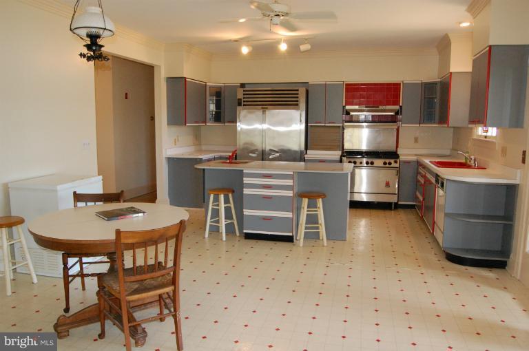 6937 Pea Neck Road St. Michaels, MD 21663 - Photo 7 of 22 a kitchen with stainless steel appliances a sink a stove a refrigerator cabinets and dining table