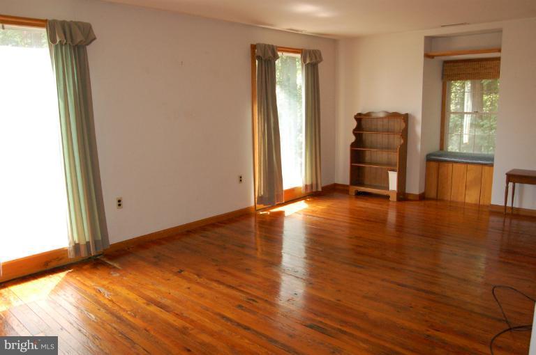 6937 Pea Neck Road St. Michaels, MD 21663 - Photo 10 of 22 a view of an empty room with window and wooden floor