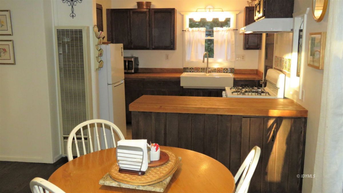 27300 Saunders Meadow Road Idyllwild, CA 92549 - Photo 6 of 39 a view of a dining room with furniture a kitchen and chandelier