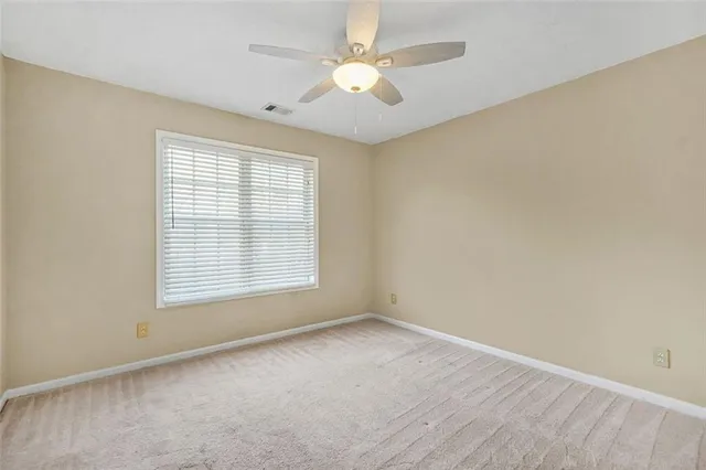 an empty room with a ceiling fan and a fan
