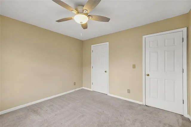 an empty room with a ceiling fan and a fan