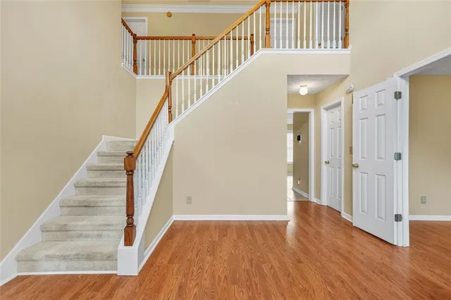 a view of staircase with wooden floor and white walls