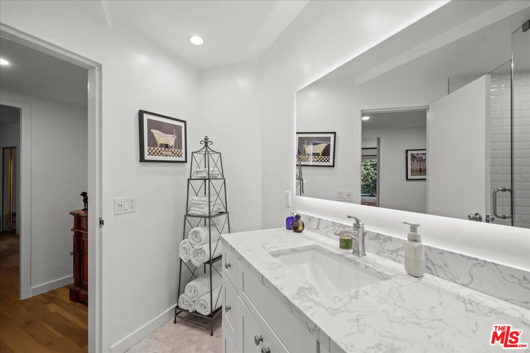 7250 Franklin Avenue, Unit 101 Los Angeles, CA 90046 - Photo 14 of 33 a bathroom with a granite countertop sink a mirror and shower