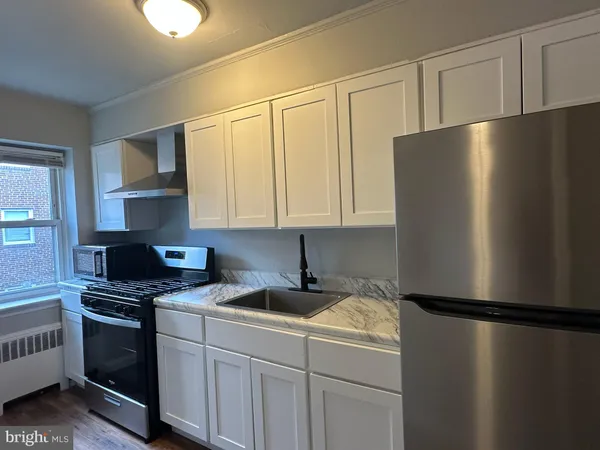 a kitchen with a refrigerator a stove a sink and cabinets