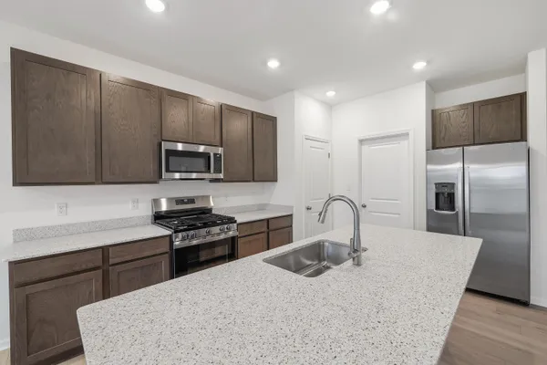 a kitchen with stainless steel appliances granite countertop microwave stove and refrigerator