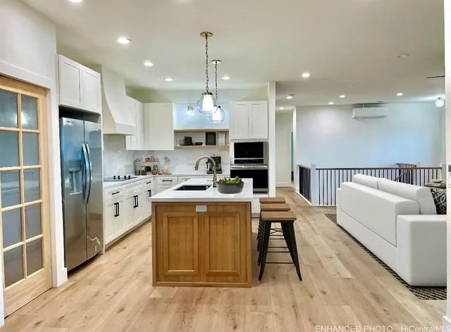 a kitchen with kitchen island stainless steel appliances a stove a sink and a refrigerator