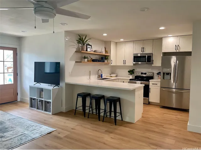 a kitchen with white cabinets and stainless steel appliances