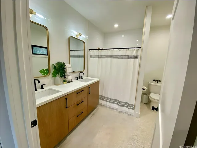 a bathroom with a sink and mirror with toilet